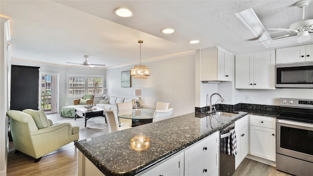 1257 S Portofino Dr Unit 306, Sarasota, FL 34242 - kitchen with appliances with stainless steel finishes, a ceiling fan, white cabinetry, recessed lighting, and crown molding