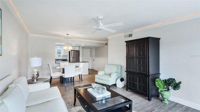 1257 S Portofino Dr Unit 306, Sarasota, FL 34242 - living area featuring a ceiling fan, light wood-type flooring, and crown molding