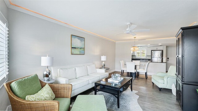 1257 S Portofino Dr Unit 306, Sarasota, FL 34242 - living area with light wood-type flooring, ceiling fan, crown molding, and baseboard heating