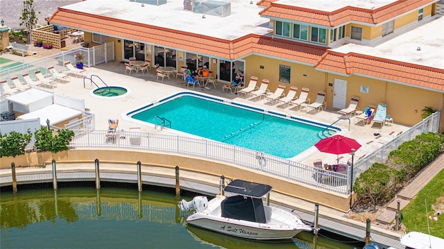 1257 S Portofino Dr Unit 306, Sarasota, FL 34242 - community pool with a fenced backyard, a patio area, and a water view