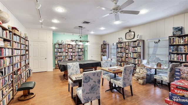 1257 S Portofino Dr Unit 306, Sarasota, FL 34242 - living area with wall of books, wood finished floors, and a ceiling fan