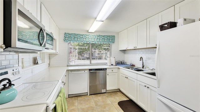 1257 S Portofino Dr Unit 306, Sarasota, FL 34242 - kitchen featuring stainless steel appliances, tasteful backsplash, light tile patterned floors, and white cabinetry