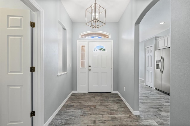 1042 Whitegate Ct, Sarasota, FL 34232 - foyer entrance with arched walkways, dark wood finished floors, and a chandelier