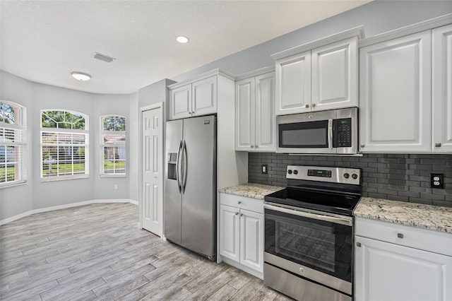 1042 Whitegate Ct, Sarasota, FL 34232 - kitchen featuring stainless steel appliances, tasteful backsplash, light wood-style flooring, white cabinetry, and recessed lighting