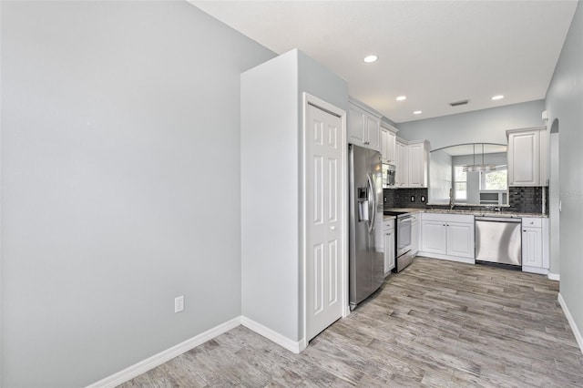 1042 Whitegate Ct, Sarasota, FL 34232 - kitchen with stainless steel appliances, light wood-type flooring, decorative backsplash, recessed lighting, and light stone countertops