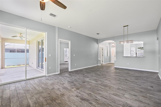 1042 Whitegate Ct, Sarasota, FL 34232 - unfurnished living room featuring ceiling fan, wood finished floors, and arched walkways
