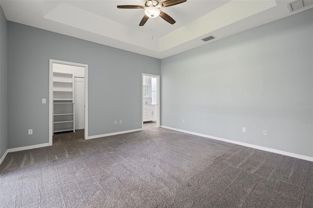 1042 Whitegate Ct, Sarasota, FL 34232 - spare room featuring dark colored carpet, a ceiling fan, and a tray ceiling