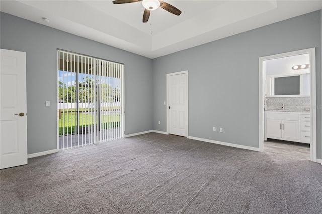 1042 Whitegate Ct, Sarasota, FL 34232 - unfurnished bedroom featuring carpet floors, access to exterior, a tray ceiling, ensuite bath, and ceiling fan