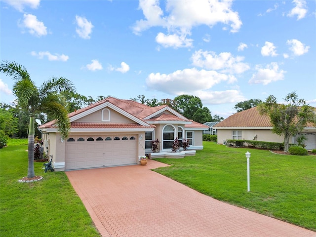 7115 39th Ln E, Sarasota, FL 34243 - mediterranean / spanish house featuring stucco siding, decorative driveway, a garage, a front lawn, and a tile roof