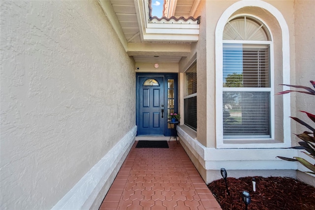 7115 39th Ln E, Sarasota, FL 34243 - property entrance featuring stucco siding and a surveillance system