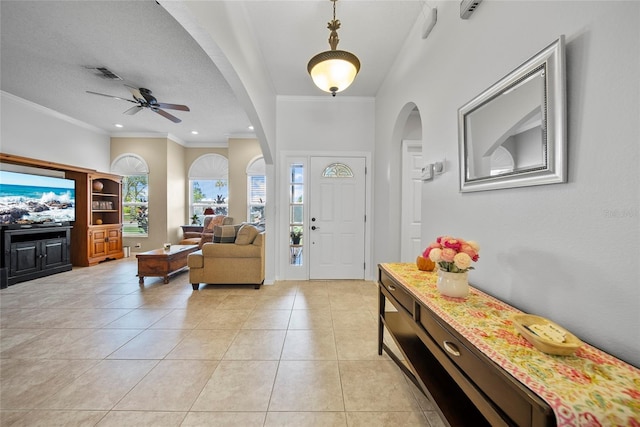 7115 39th Ln E, Sarasota, FL 34243 - entryway with arched walkways, a ceiling fan, ornamental molding, light tile patterned floors, and recessed lighting