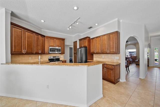 7115 39th Ln E, Sarasota, FL 34243 - kitchen featuring appliances with stainless steel finishes, arched walkways, light tile patterned flooring, ornamental molding, and recessed lighting
