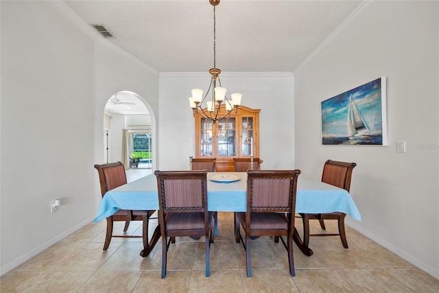 7115 39th Ln E, Sarasota, FL 34243 - dining area featuring a chandelier, arched walkways, crown molding, and light tile patterned floors