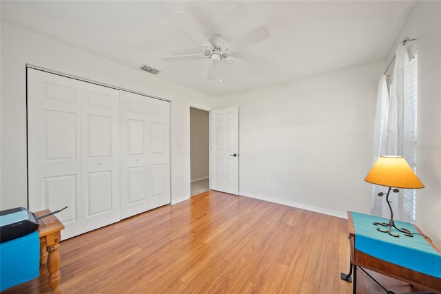 7115 39th Ln E, Sarasota, FL 34243 - bedroom with light wood finished floors, a closet, and ceiling fan