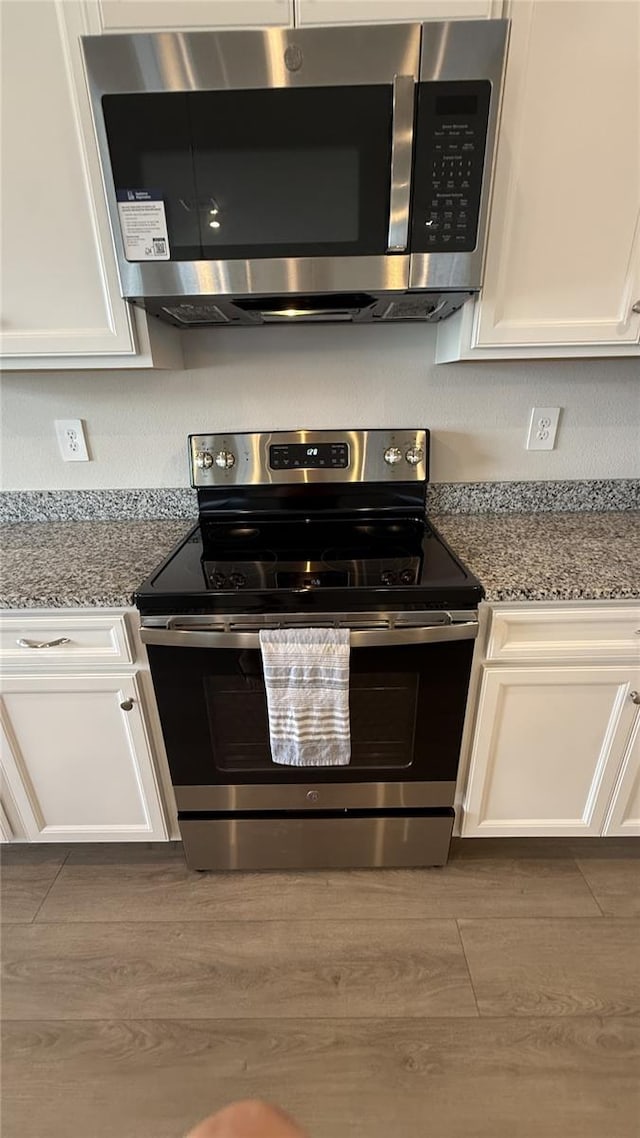 14312 Crimson Ave, Bradenton, FL 34211 - kitchen with stainless steel appliances, white cabinets, and wood finished floors