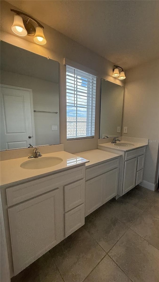 14312 Crimson Ave, Bradenton, FL 34211 - full bathroom featuring two vanities, a textured ceiling, and tile patterned floors