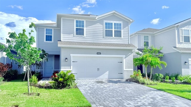 14312 Crimson Ave, Bradenton, FL 34211 - traditional-style house with decorative driveway, an attached garage, a front yard, and a shingled roof
