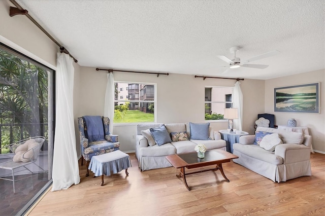 6188 80th St N Unit 102, Saint Petersburg, FL 33709 - living room featuring a textured ceiling, light wood-style floors, plenty of natural light, and a ceiling fan