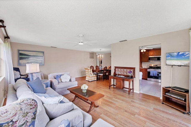 6188 80th St N Unit 102, Saint Petersburg, FL 33709 - living room featuring ceiling fan, light wood finished floors, and a chandelier