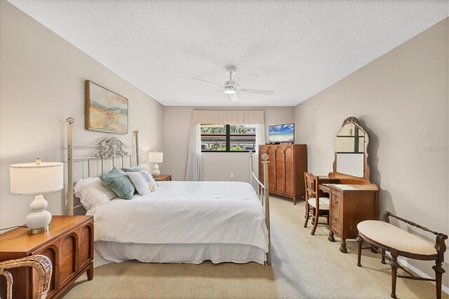 6188 80th St N Unit 102, Saint Petersburg, FL 33709 - bedroom with light colored carpet, a textured ceiling, and a ceiling fan