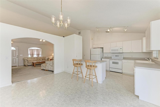 7824 48th Pl E, Bradenton, FL 34203 - kitchen featuring white appliances, lofted ceiling, arched walkways, a breakfast bar, and open floor plan