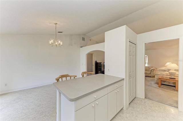 7824 48th Pl E, Bradenton, FL 34203 - kitchen with arched walkways, lofted ceiling, light colored carpet, a peninsula, and a chandelier