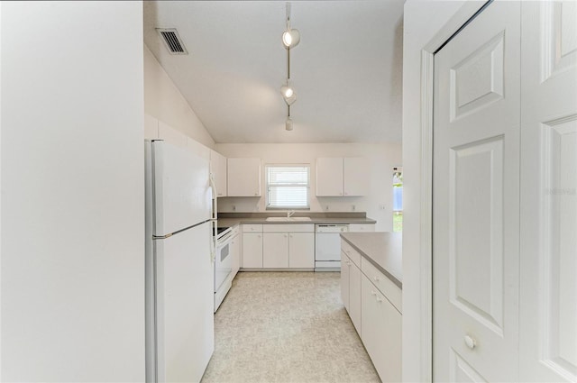 7824 48th Pl E, Bradenton, FL 34203 - kitchen with white appliances, vaulted ceiling, white cabinets, track lighting, and light carpet