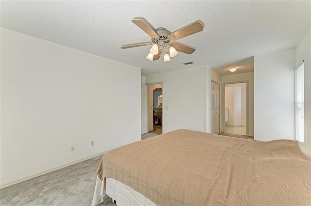 7824 48th Pl E, Bradenton, FL 34203 - bedroom with arched walkways, light colored carpet, ensuite bath, and a ceiling fan