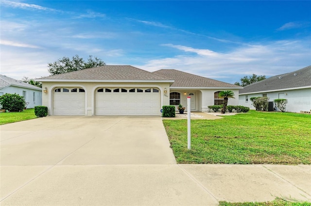 7824 48th Pl E, Bradenton, FL 34203 - ranch-style home with stucco siding, an attached garage, concrete driveway, a front lawn, and roof with shingles