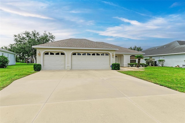 7824 48th Pl E, Bradenton, FL 34203 - ranch-style home featuring stucco siding, an attached garage, driveway, a front lawn, and roof with shingles