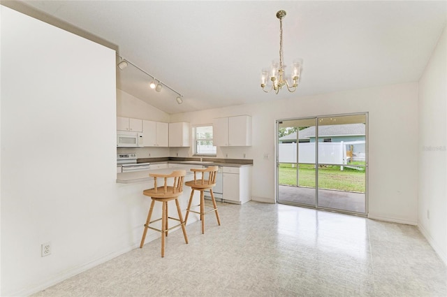 7824 48th Pl E, Bradenton, FL 34203 - kitchen with white appliances, a chandelier, lofted ceiling, a breakfast bar area, and white cabinets