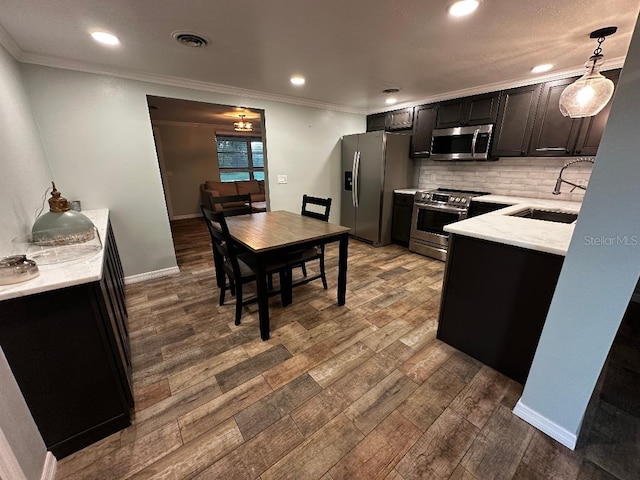 611 Missouri Rd, Venice, FL 34293 - kitchen featuring stainless steel appliances, dark wood-type flooring, backsplash, ornamental molding, and pendant lighting