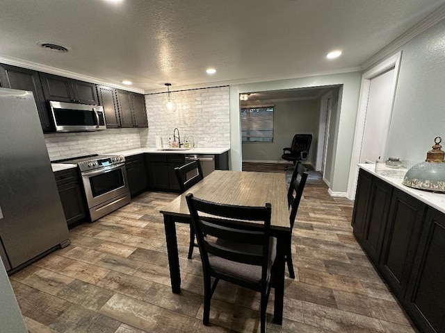 611 Missouri Rd, Venice, FL 34293 - kitchen with stainless steel appliances, light countertops, decorative backsplash, ornamental molding, and dark wood finished floors