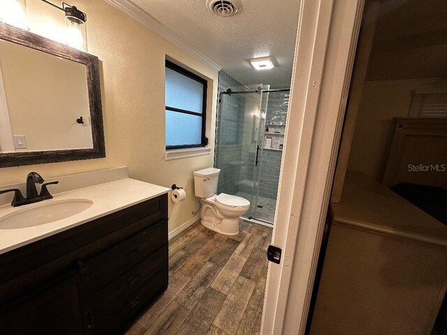 611 Missouri Rd, Venice, FL 34293 - full bathroom with vanity, a stall shower, a textured ceiling, wood finished floors, and crown molding