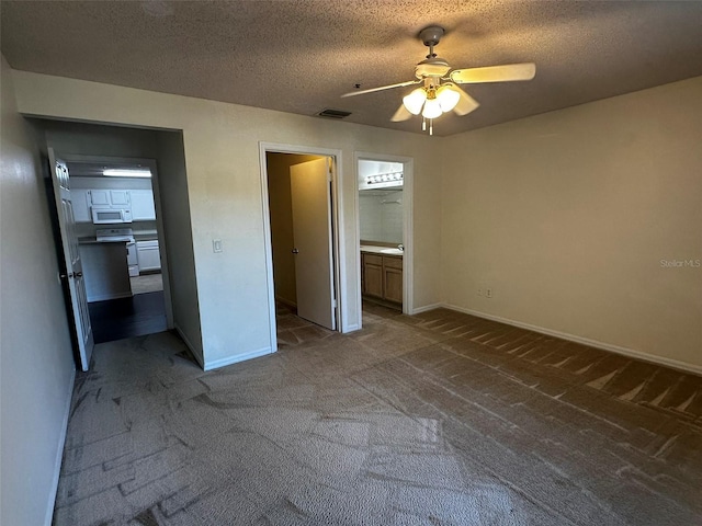 4002 Crockers Lake Blvd Unit 11, Sarasota, FL 34238 - unfurnished bedroom featuring carpet, a textured ceiling, ceiling fan, and ensuite bath