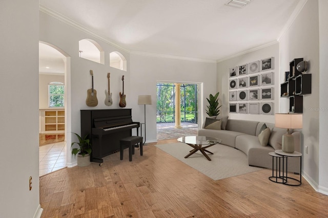 12113 Whistling Way, Lakewood Ranch, FL 34202 - living area featuring ornamental molding, plenty of natural light, wood finished floors, and arched walkways