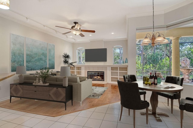 12113 Whistling Way, Lakewood Ranch, FL 34202 - living area with ornamental molding, light tile patterned floors, a chandelier, healthy amount of natural light, and a fireplace