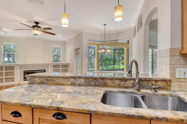 12113 Whistling Way, Lakewood Ranch, FL 34202 - kitchen featuring light stone counters, crown molding, ceiling fan, and open floor plan