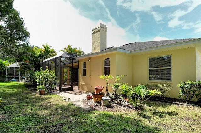 12113 Whistling Way, Lakewood Ranch, FL 34202 - back of house with a yard, stucco siding, a chimney, and a patio area