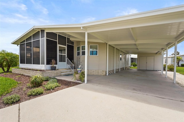 8470 Imperial Cir, Palmetto, FL 34221 - manufactured / mobile home with concrete driveway, a sunroom, and an attached carport