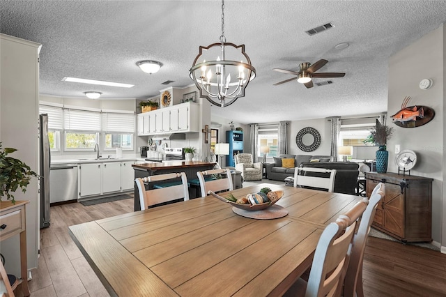 8470 Imperial Cir, Palmetto, FL 34221 - dining room with a textured ceiling, a chandelier, light wood-type flooring, and ceiling fan