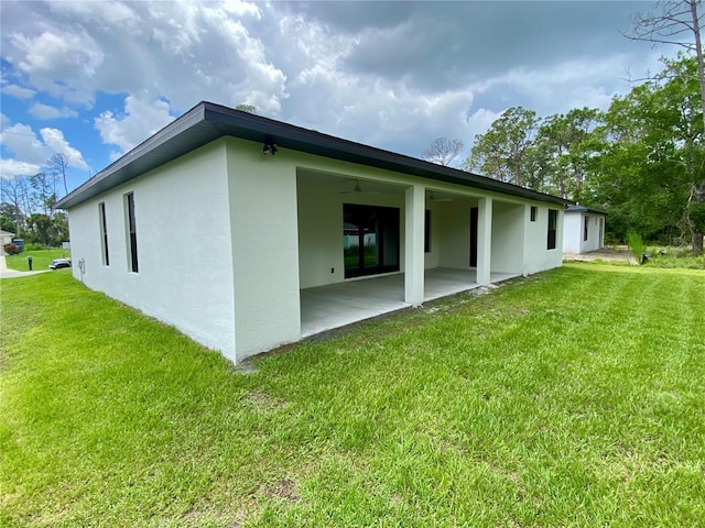 3616 Bellefonte Ave, North Port, FL 34286 - back of property with stucco siding, a patio area, and a lawn