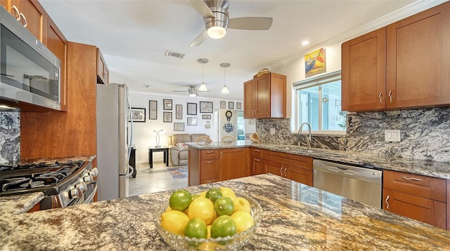 5524 Antilles Dr, Sarasota, FL 34231 - kitchen featuring stainless steel appliances, a ceiling fan, backsplash, brown cabinets, and stone counters