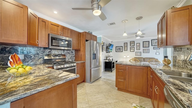 5524 Antilles Dr, Sarasota, FL 34231 - kitchen featuring appliances with stainless steel finishes, a ceiling fan, ornamental molding, a peninsula, and dark stone countertops