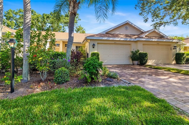 2411 New Haven Cir Unit 70, Sun City Center, FL 33573 - ranch-style home featuring stucco siding, decorative driveway, and a garage