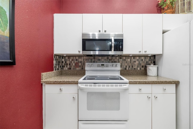 2411 New Haven Cir Unit 70, Sun City Center, FL 33573 - kitchen featuring stainless steel microwave, white range with electric stovetop, tasteful backsplash, a textured wall, and white cabinets