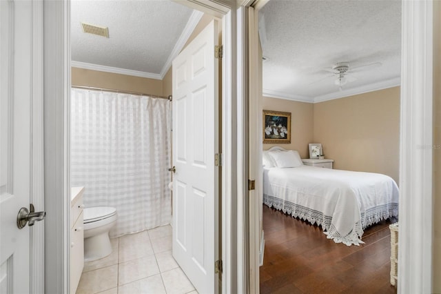 2411 New Haven Cir Unit 70, Sun City Center, FL 33573 - bedroom featuring a textured ceiling, crown molding, a ceiling fan, and ensuite bathroom