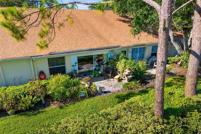 2411 New Haven Cir Unit 70, Sun City Center, FL 33573 - view of front of property featuring roof with shingles, a patio area, and stucco siding