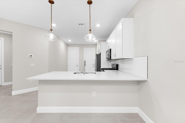 7661 Summerland Cv, Bradenton, FL 34202 - kitchen with range, a peninsula, white cabinets, recessed lighting, and light countertops