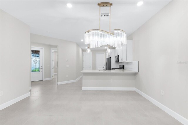 7661 Summerland Cv, Bradenton, FL 34202 - kitchen featuring appliances with stainless steel finishes, white cabinets, a peninsula, recessed lighting, and light countertops